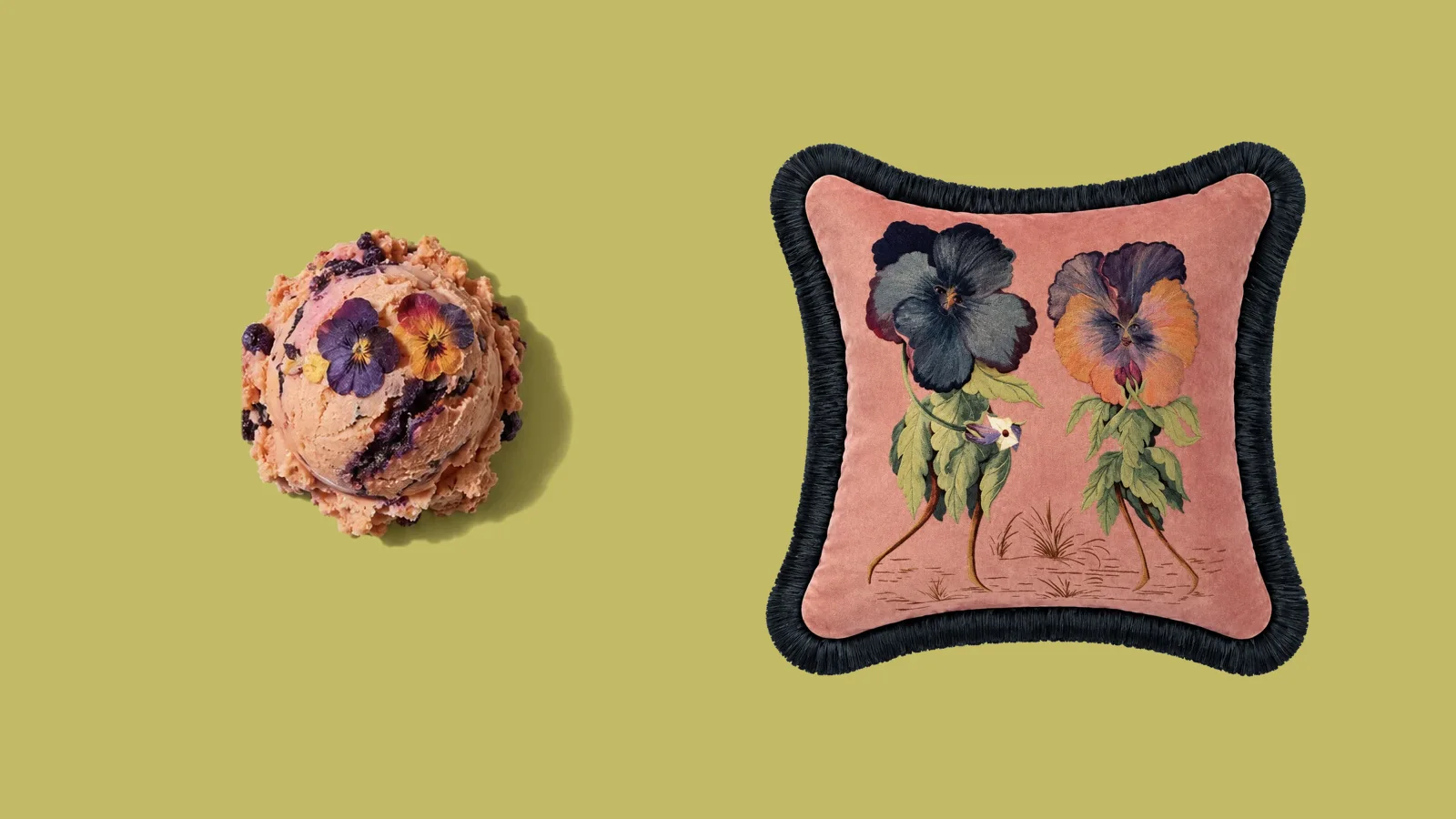A peach ice cream scoop with pansies beside a pink velvet pansy cushion