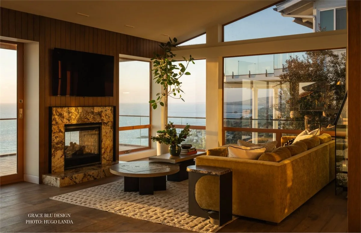 Living room at golden hour with ocean view and ochre velvet sofa